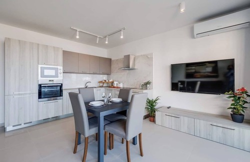Għadira Apartment | Cosy Mellieħa apartment 🏖️ just steps from the beach with sea views, terrace, 1 bedroom + ensuite, modern kitchen & lift access. Perfect for couples or business stays 🌴.