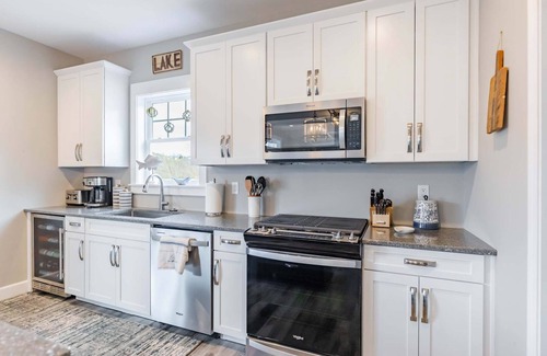 Ingles House | Modern lakefront home with wraparound decks, firepit, and stunning water views on both levels.