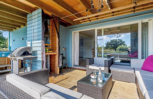 Hopton Cottage | Relax in the hot tub whilst enjoying open views over the golf course and lakes.