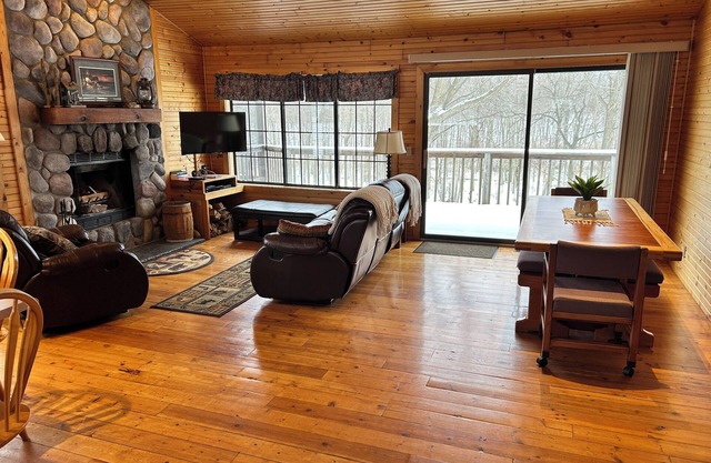Riverbend Retreat Middle Branch CottagenFireplace and hot tub with river view.