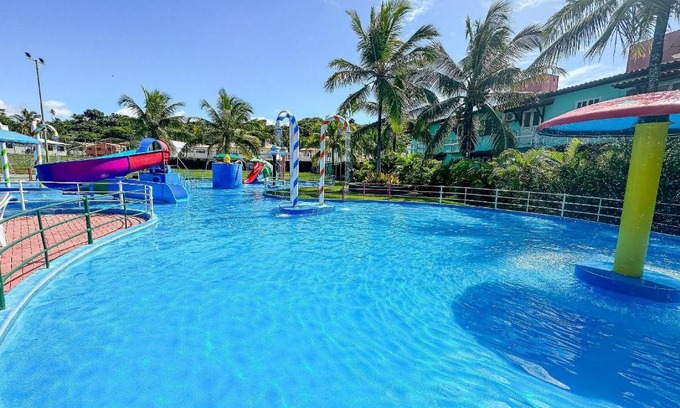 Taperapua Beach House | Suiíte com ar condicionado, frigobar e mesa para trabalho. Localizada no Hotel Porto Belo Park, com parque aquático (sem custo para a utilização), quadras, academia, espaço kids, a aproximadamente 200 m praia de Taperapuã e do complexo Axé Mói.