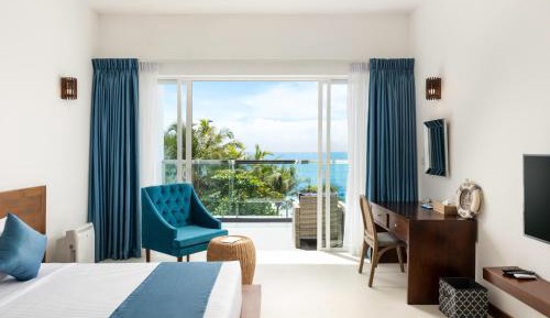 Deluxe Double Room with Balcony and Sea View with homemade Sorbet, a tropical evening mocktail, local snacks with tea/coffee, and a dining experience by the white sands