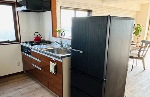 Mihokan Onsen Apartment | A panoramic view of Lake ShinjiSpacious living s / Matsue Shimane